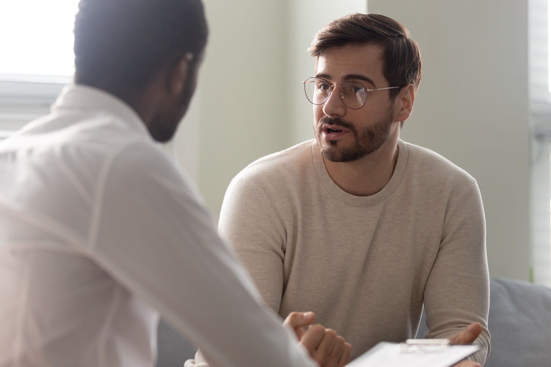 African counsellor sitting in front of patient listens his complaints